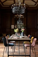 Table à manger moderne et chaises dépareillées dans une salle à manger classique avec des éléments d'époque