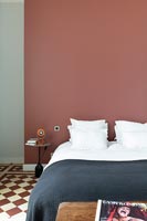 Chambre moderne avec mur en terre cuite rouge et sol en damier