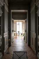 Couloir lambrissé avec parquet peint en couleurs sombres