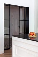 Portes intérieures coulissantes en verre à cadre noir dans la cuisine