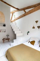 Escalier dans une chambre moderne blanc et marron avec poutres apparentes