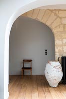 Grande urne vide peint dans le couloir avec mur en pierres apparentes