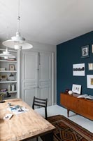 Mobilier vintage et mur peint en bleu dans une étude moderne