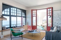 Salon moderne avec vue sur la mer et portes-fenêtres ouvertes sur la terrasse