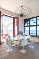 Salle à manger moderne avec vue sur la mer et portes-fenêtres ouvertes menant à la terrasse