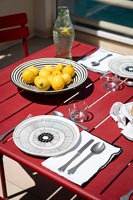 Citrons dans un bol noir et blanc sur une table à manger extérieure rouge