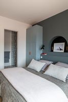 Chambre moderne avec mur peint en gris et vue sur la salle de bains privative