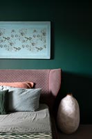 Tête de lit rembourrée rose dans une chambre moderne verte