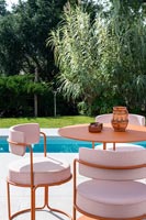 Chaises rembourrées et table de style café sur terrasse à côté de la piscine