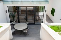 Terrasse en bois moderne avec table circulaire et chaises