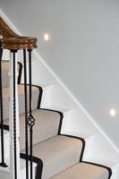 Escalier classique avec tapis de passage et spots