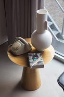 Grand vase moderne et téléphone vintage sur petite table d'appoint en bois