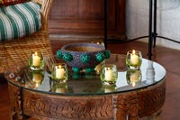 Bougies dans de petits verres sur table basse en bois sculpté