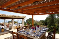 Grande table à manger sous terrasse couverte prévue pour le déjeuner en été
