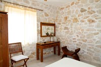 Murs en pierres apparentes et meubles en bois dans la chambre de campagne