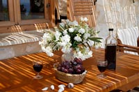 Arrangement de fleurs, raisins et vin sur table à manger extérieure