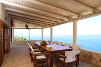 Grand coin repas sur terrasse couverte avec vue mer