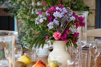 Détail de l'arrangement floral sur la table à manger extérieure prévue pour le déjeuner