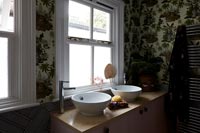Papier peint à motifs et double vasque dans salle de bain moderne