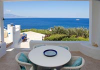 Table et chaises sur terrasse ombragée avec vue mer