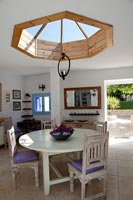 Country salle à manger avec puits de lumière en bois circulaire au-dessus de la table