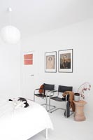 Chaises design en cuir noir et chrome dans une chambre blanche moderne