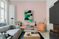 Mur caractéristique peint en rose pâle avec radiateur vertical dans un salon contemporain