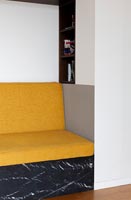 Coussins de canapé jaunes sur siège intégré dans l'alcôve