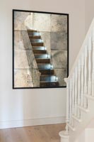 Miroir antique reflétant les escaliers dans le couloir moderne
