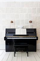 Mur recouvert de partitions avec piano