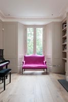 Canapé deux places rose vif dans le salon classique