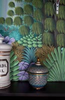 Pot décoratif à côté de mur tapissé coloré