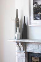 Bouteilles en céramique sur cheminée en marbre gris