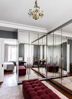 Grandes armoires encastrées en miroir dans un dressing de style rétro