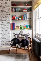 Deux ours tricotés assortis sur une chaise en bois à deux places dans la chambre des enfants