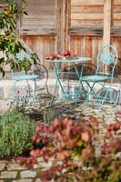 Petite table et chaises de style café en métal bleu sur terrasse