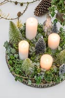 Arrangement de l'Avent avec bougies blanches, faux sapins de Noël miniatures