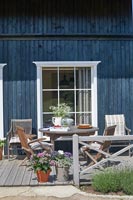 Table et chaises en bois sur une terrasse à l'extérieur de la maison de campagne