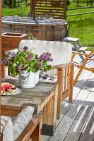 Fleurs sur table de jardin avec bain à remous en arrière-plan