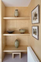 Bols et vases en céramique sur mur d'étagères en bois