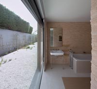 Salle de bain contemporaine avec grande porte-fenêtre ouverte donnant sur le jardin clos