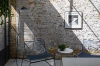 Chaises basses et table dans un salon moderne avec mur de briques apparentes