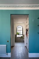 Murs peints en turquoise et corniches sur la porte du couloir