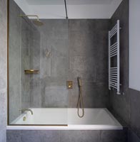 Salle de bain moderne grise et blanche avec robinets en or