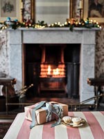 Cadeau de Noël et tartes hachées devant la cheminée