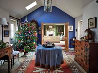 Couloir peint en bleu avec table centrale et arbre de Noël