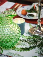 Détail de la table à manger avec pichet en verre texturé et chandelier en argent