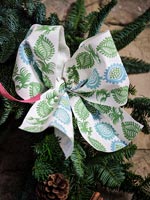 Détail de noeud en tissu à motifs bleu et vert sur guirlande de Noël