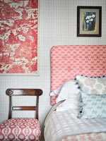 Tête de lit et housse de chaise en tissu à motifs dans la chambre de campagne