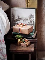 Cadeaux de Noël emballés et petite plante succulente sur table de chevet